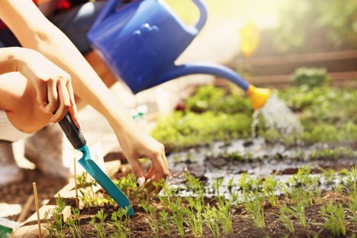 Company van and gardener preparing tools at a job site