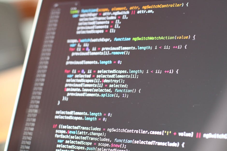 A close-up view of a computer screen displaying colorful lines of code used for website development or programming, with the text comprising various syntax elements in bright hues such as pink, blue, 